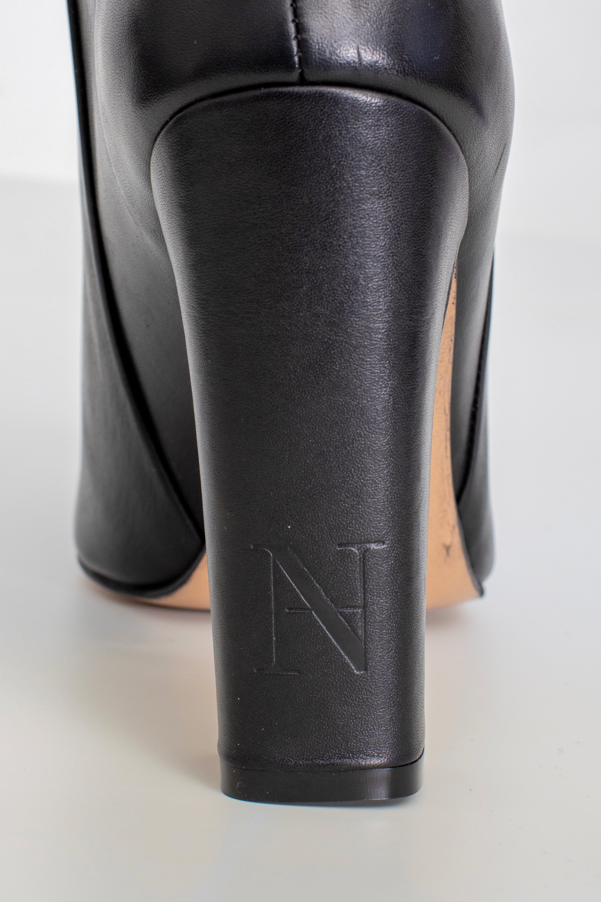 Zoom sur le talon aiguille de 11 cm des bottes Elegance noires en cuir, adaptées aux gros mollets