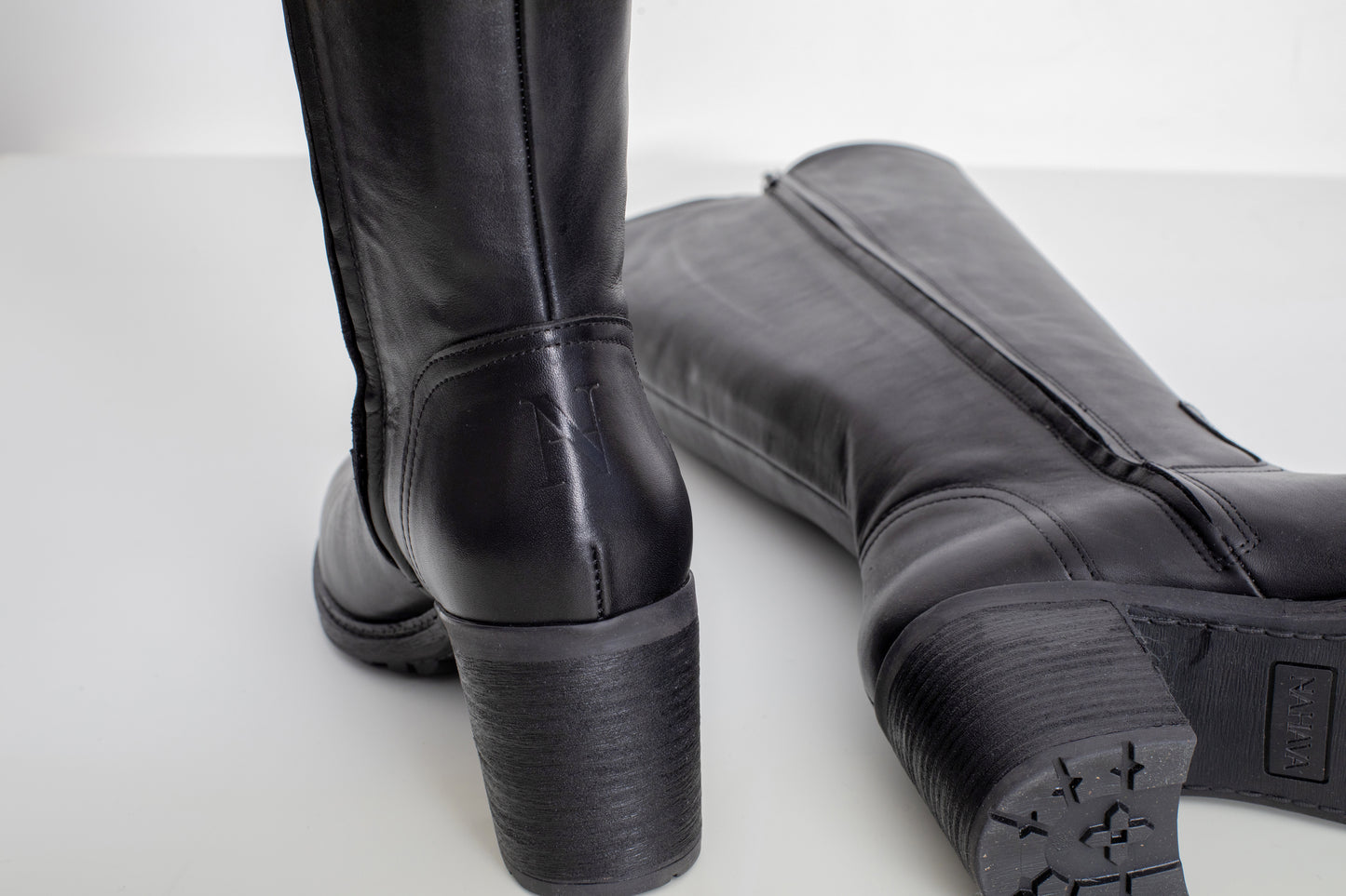zomme sur de le talon de la botte attitude noir en cuir avec le logo de la marque gravée derrière de la couleur de la botte, bottes pour gros mollets