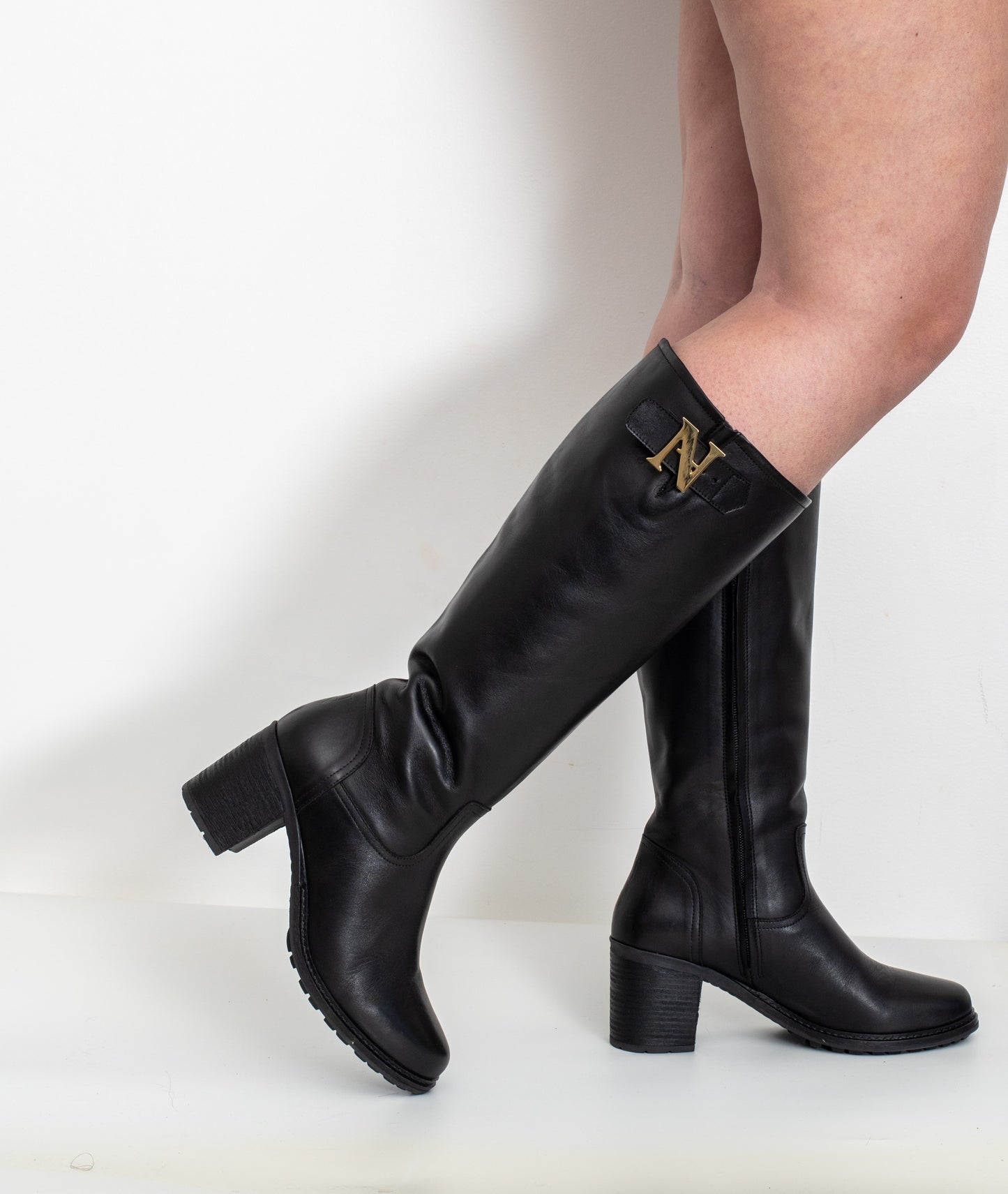 Profil des bottes Attitude noir en cuir portées, pour mollets larges avec talon 6 cm, détail « N » métal doré