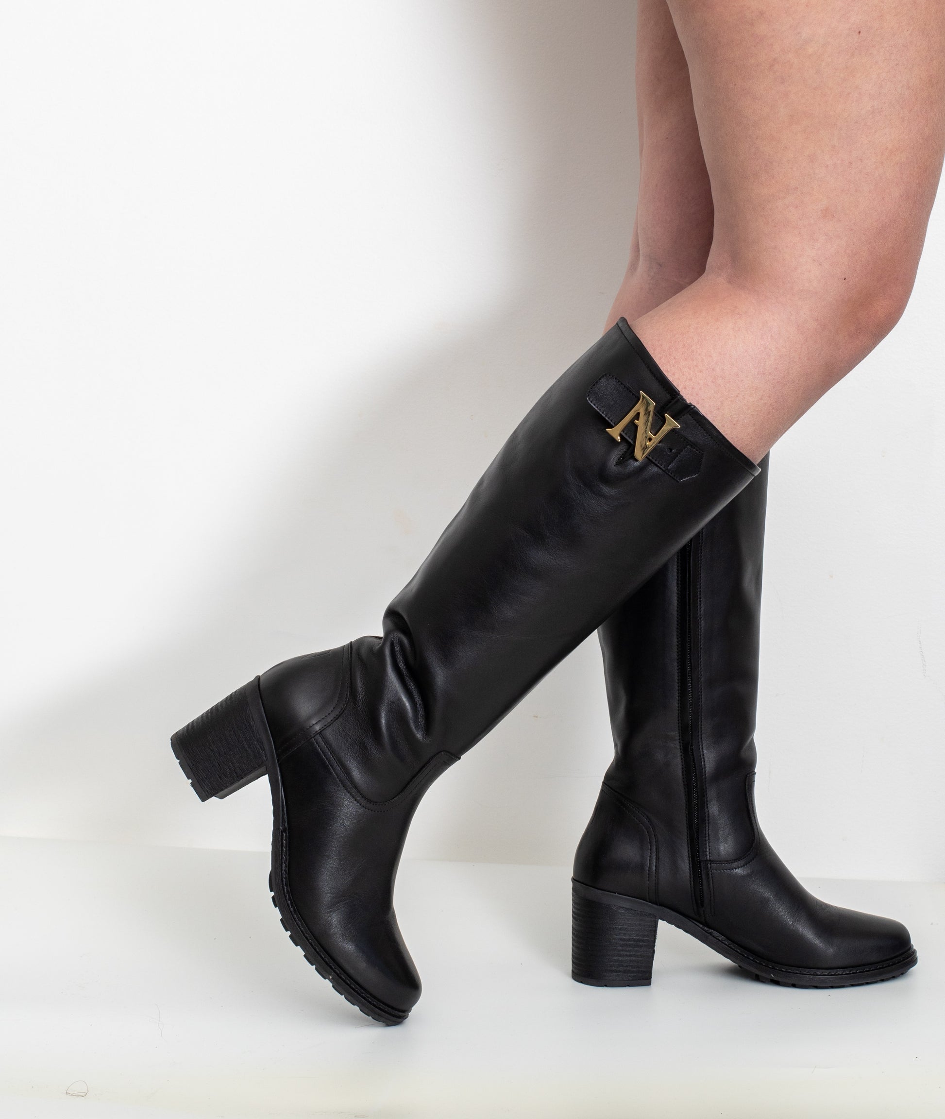 Profil des bottes Attitude noir en cuir portées, pour mollets larges avec talon 6 cm, détail « N » métal doré
